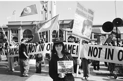Demonstration photo with woman wearing a SEIU hat in front of a not in our name banner