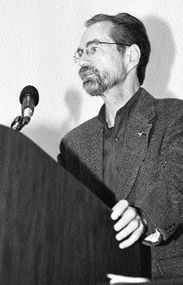 Allen Davenport spekaing at podium, looking stern