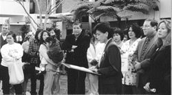 speakerss at arally,  Judy Chow is speaking at the podium, it is an out door rally infront of Garfield Hospital