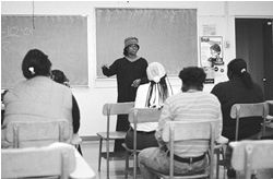 Tamika infront of a classroom lecturing students