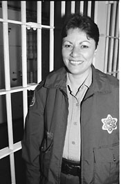 Kathy Schwartz standing next to jail cell bars
