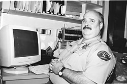 Harry Gann at a desk with a computer monitor 
