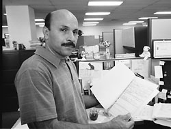 photo of Garcia holding up an open file folder with documentation