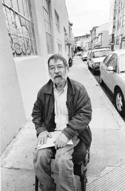 Charles Houck in his wheelchair traveling down the side walk