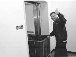 Hector moving a laundry cart and giving the thumbs up sign