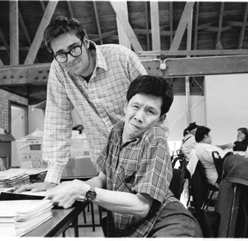 John standding next to a client who is working at a table