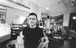 Scott Amyx in his tea house with customers sitting in the background.