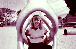 social worker at a playground, with trees and dramatic sky in the background