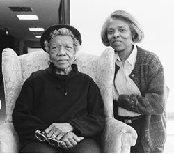 Jackson next to her mother who is sitting in an easy chair looking contented with her daughter by her side