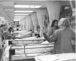 Nurses with beds stacked up, resembling a factor assembly line