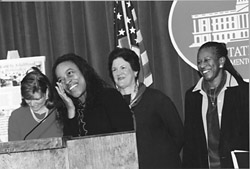 Tamika Bennett speaking with tears in her eyes, behind her is sharon davis , Dion Aroner and Annette Jeffries