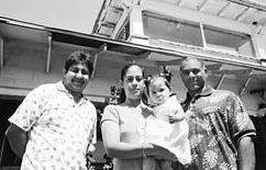 worker and clients infront of a house that the commission is helping repair