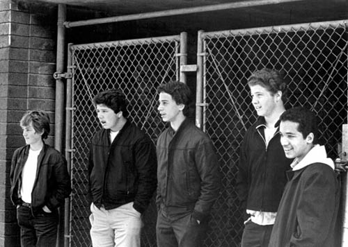 schoolKids haniging out by a chain link fence